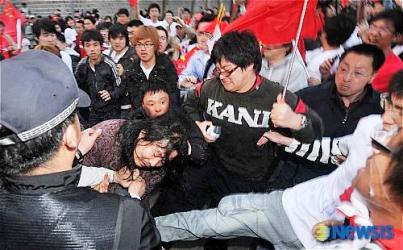 年配のチベット人女性を襲撃する中国人
